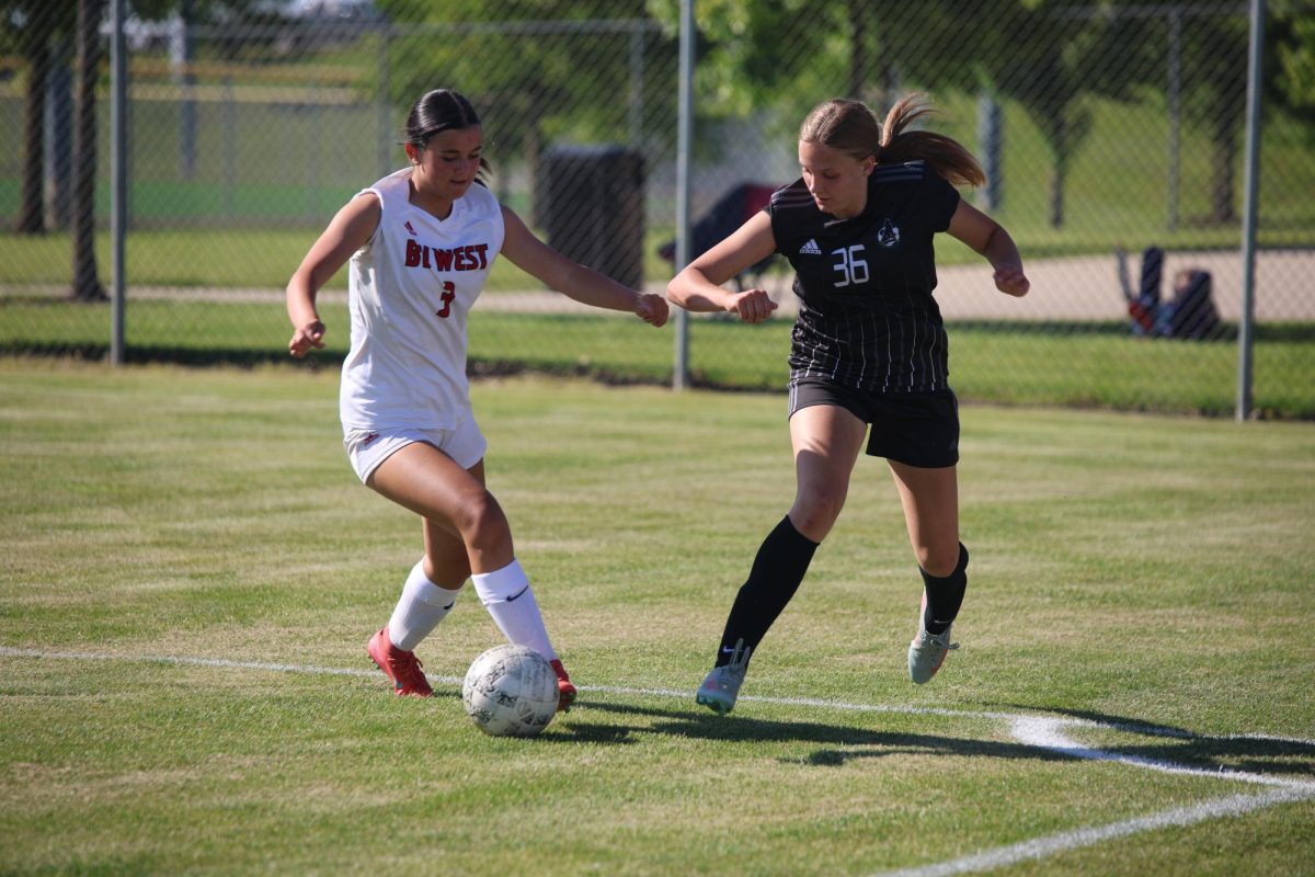 Arm out, freshman Ashley Gerlach prepares to try to win ball against Blue Valley West on May 12. 