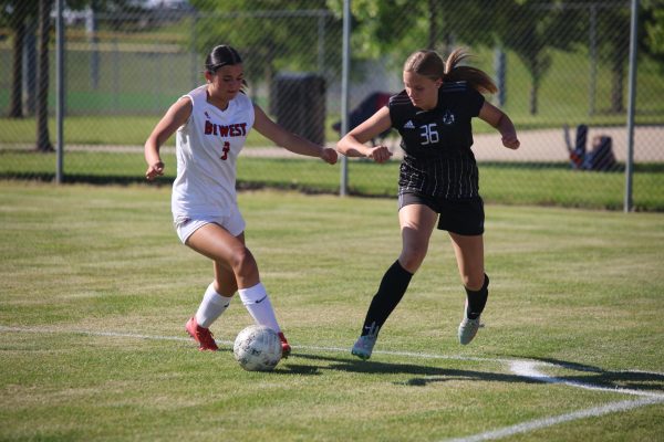 Arm out, freshman Ashley Gerlach prepares to try to win ball against Blue Valley West on May 12. 